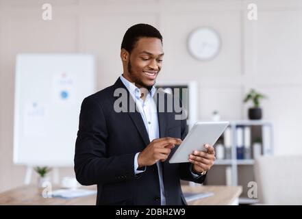 Happy african american businessman using digital tablet Stock Photo