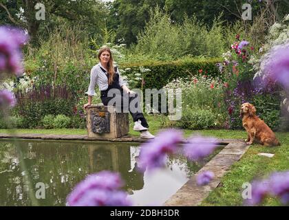 Interior designer Flora Soames and her dog Humbug, photographed at her Wiltshire home. Flora wears Carrier Company dungarees, With Nothing Underneath Stock Photo