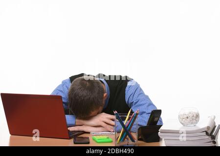 sleeping employee in the office at the table put his head on his hands Stock Photo