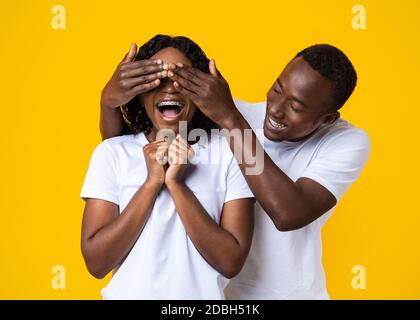 Portrait Of Black Guy Covering Eyes With Hearts, Yellow Background Stock  Photo - Alamy