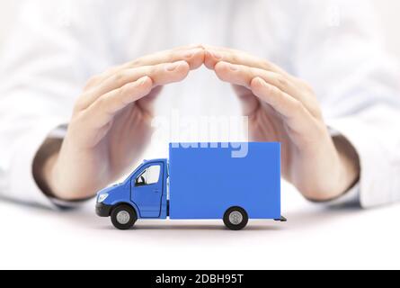 Blue cargo delivery truck protected by hands Stock Photo