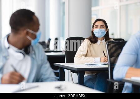 Diverse students wearing medical masks and talking Stock Photo