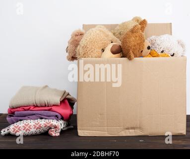 brown cardboard box filled with things and children's toys, concept of moving, volunteering and help Stock Photo