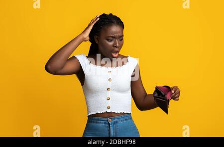 Oh No. Shocked Black Woman Looking At Empty Wallet In Her Hands Stock Photo