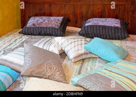 Bunch of pillows and blankets over double bed Stock Photo