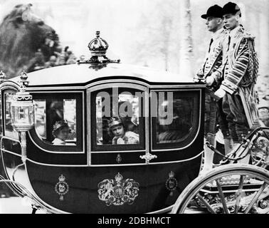 Elizabeth II (right), Margaret Rose (left) and Queen Mother Mary with golden diadem (hidden behind Elizabeth) in the carriage during the return procession across Trafalgar Square. The two princesses are wearing their crowns. Stock Photo