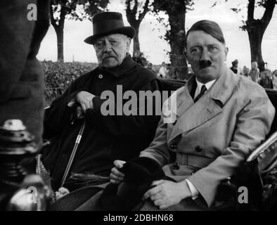 Adolf Hitler in a trench coat and Paul von Hindenburg on one of the last common pictures taken during a carriage ride on the Neudeck estate. Stock Photo