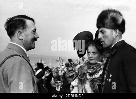 Adolf Hitler is talking to a peasant couple in traditional costumes during the Bueckebergfest (Reich Harvest Thanksgiving Festival). Stock Photo