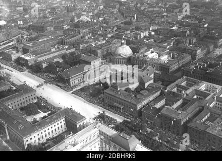 The aerial photograph from 1926 shows the boulevard Unter den Linden with the Neue Wache, the Humboldt University and the State Library in Berlin-Mitte. A parade is taking place and many people are watching it. In the center of the picture is the St. Hedwig's Cathedral on Bebelplatz and the State Opera. Stock Photo