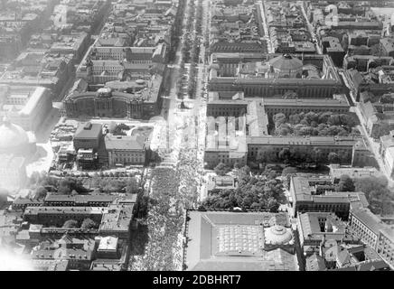 The aerial photograph from 1926 or 1927 shows the wide boulevard Unter den Linden in Berlin, where a crowd of people has gathered. On the left side (from front to back): the Kronprinzenpalais, the Prinzessinnenpalais, the Staatsoper (which has just been rebuilt), the Sankt-Hedwigs-Kathedrale (far left) and the Alte Bibliothek am Bebelplatz as well as the Alte Palais. On the right side (from front to back) the Zeughaus, the Neue Wache, the Humboldt-Universitaet and the Staatsbibliothek. Stock Photo