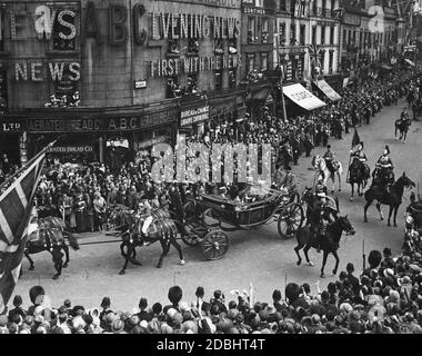 King Victor Victor Emanuel III of Italy (right) leaves the London Victoria Station together with King George V (left), to go to the Buckingham Palace during his state visit. In the carriage are also the Prince of Piedmont and Edward, Prince of Wales. Stock Photo