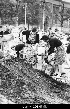 Women fill bags with sand for air defense in London's Kensington district. Stock Photo