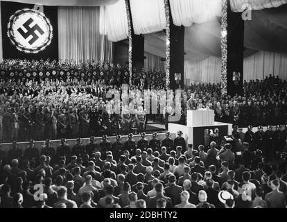 Rudolf Hess gives a speech in the Nuremberg Luitpoldhalle at the opening of the party congress of the NSDAP, here in memory of the late Reich President Paul von Hindenburg. In the 1st row, from right (left side): Julius Streicher, Adolf Hitler (behind him Wilhelm Brueckner), Viktor Lutze, Heinrich Himmler, Franz Xaver Schwarz, Robert Ley, Joseph Goebbels. Right side next to Rudolf Hess: Hermann Goering. Stock Photo