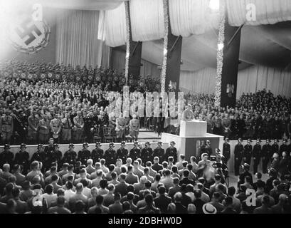 SA Chief of Staff Viktor Lutze reads out the names of the victims of the National Socialist movement at the opening of the NSDAP party congress in Nuremberg's Luitpoldhalle. In the first row, from right (left side): Julius Streicher, Adolf Hitler (behind him Wilhelm Brueckner), Heinrich Himmler, Franz Xaver Schwarz, Robert Ley, Joseph Goebbels. Stock Photo