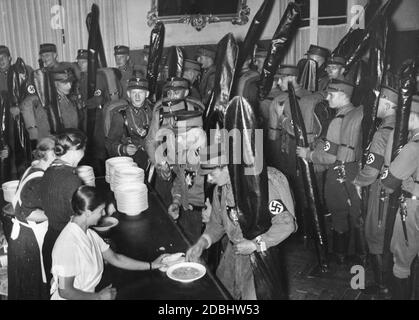 The flag bearers of the Berlin-Brandenburg and Ostmark groups receive their rations at the roll call for the journey from Lichterfelde Ost station to Berlin to the special train to Nuremberg. Stock Photo