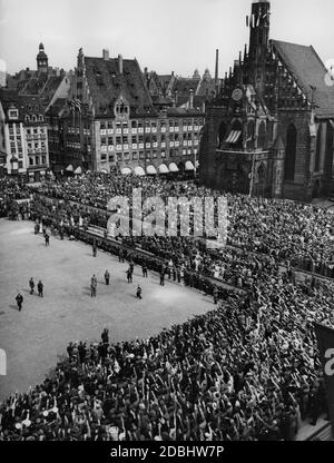 View of the grandstands at the so-called Adolf-Hitler-Platz. In the middle of the square Adolf Hitler is greeting guests of honour. Behind him, Wilhelm Brueckner. To the right is the Frauenkirche. Stock Photo
