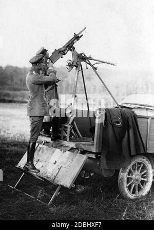 German soldiers aim at aircrafts with a captured French machine gun. In front there is an officer. Stock Photo