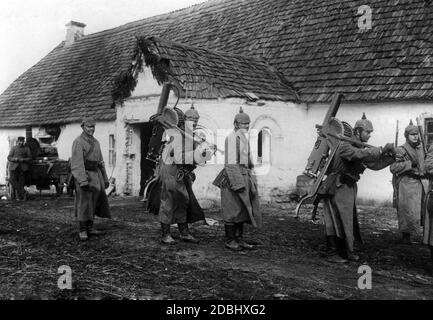 German soldiers on their way to the quarters. They carry the heavy machine guns on their backs. Stock Photo