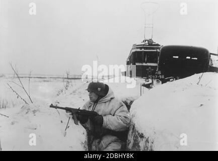 A soldier with a Maschinenpistole 40 (submachine gun) in a position during the siege of Leningrad in the winter of 1942. Photo: Freckmann. Stock Photo