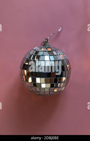 silver disco ball reflecting lights on pink background, greeting card wallpaper template with empty space for text Stock Photo