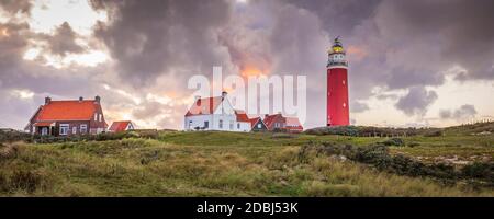 Landscape with scenic view of Lighthouse during sunset with rainy clouds at Waddenisland Texel, North Holland, Netherlands Stock Photo