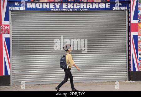 A woman wearing a protective face mask walks past a closed store on Oxford Street during the coronavirus pandemic.  London, UK 26 August 2020. Stock Photo