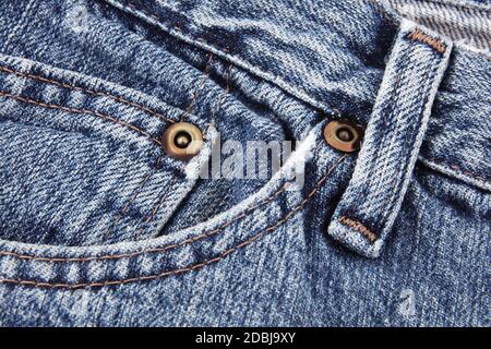 A blue jeans close up detail showing front pocket and waist band and belt loop and studs Stock Photo