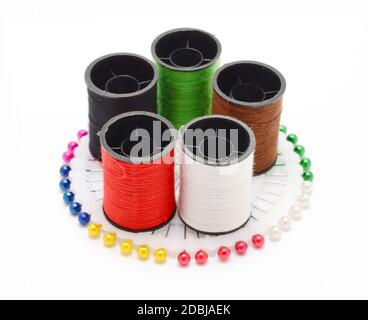 Set of color sewing threads on colorful sewing pins wheel over white background. Stock Photo