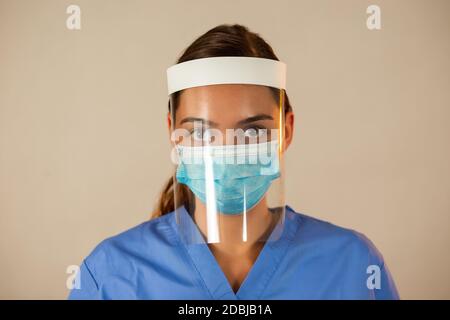Caucasian female with attached face shield with light background. Stock Photo
