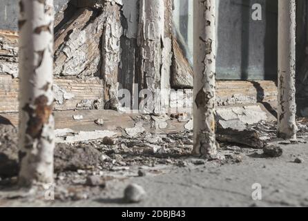 Old wooden glazed window frame with peeling paint. Empty wooden window frame and chipped wall texture. Window frame in dire need of maintenance. Stock Photo