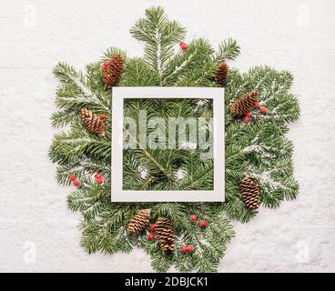 Fluffy green spruce branches white frame wooden background. Christmas concept Stock Photo