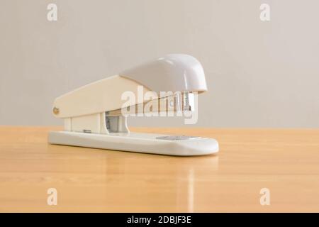 A white stapler is on the table. Stationery. Stock Photo