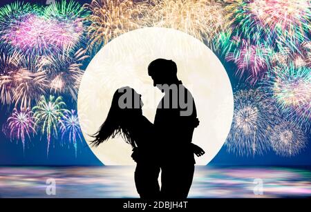 Romantic young Couple hug on the beach and fireworks background Stock Photo