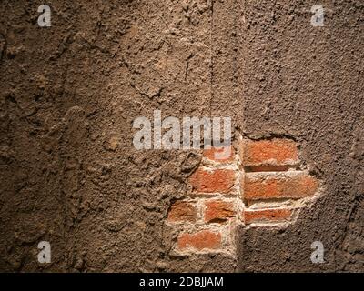 A fallen plaster on a red brick wall in an old building Stock Photo