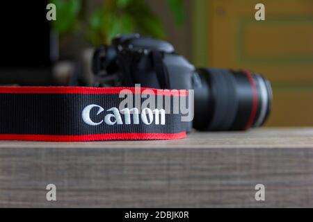 Brecht, Belgium - April 30 2020: A portrait of a canon camera strap of a camera blurred in the background lying on a table. Stock Photo