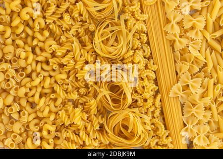 Italian foods concept and menu design. Various kind of Pasta Farfalle, Pasta A Riso, Orecchiette Pugliesi, Gnocco Sardo and Farfalle on white stone background with flat lay. Background Stock Photo