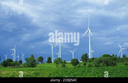 White wind turbine On the green mountains used to produce electricity.Clean energy concept. Concept of natural energy.landscape Stock Photo