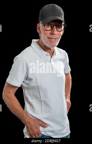 a sixty year old man wearing a baseball cap on black background Stock Photo