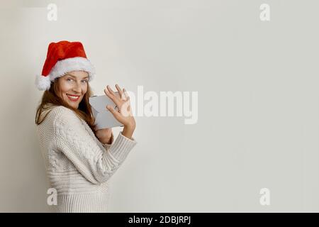 Portrait of beautiful young woman in santa hat holding paper bags Stock Photo