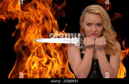 young blonde woman with a knife in the fire Stock Photo