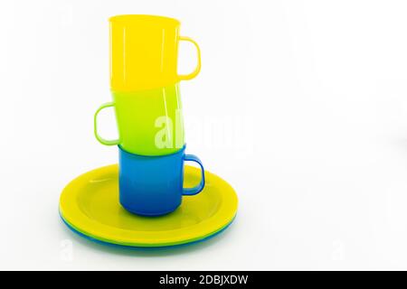 The three colored mugs and three colored saucers on a white background Stock Photo
