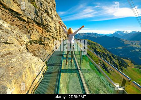 Outdoor activities in Birg, 2677, on Schilthorn in Bernese Prealps, Canton of Bern, Switzerland. Happy tourist woman walks the Thrill walk on a Stock Photo