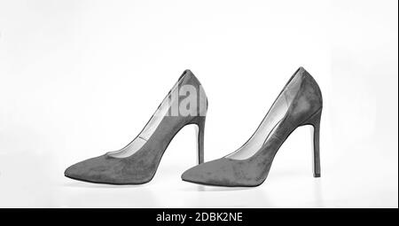 Shoes made out of red suede on white background, isolated. Pair of fashionable high heeled pump shoes. Elegant stiletto shoes concept. Footwear for women with thin high heels. Stock Photo