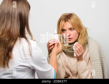 Girl in scarf hold tissue while doctor offer treatment. Cold and flu remedies. Recognize symptoms of cold. Remedies should help beat cold fast. Tips how to get rid of cold. Woman consult with doctor. Stock Photo