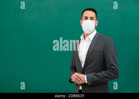 School Teacher Standing In Class Wearing Face Mask Stock Photo