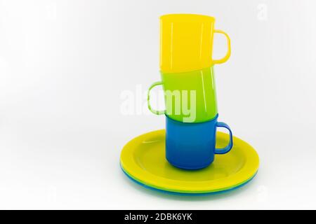 The three colored mugs and three colored saucers on a white background Stock Photo