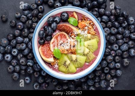 Blueberry Acai Smoothie Bowl With Kiwi, Figs, Granola And Coconut. Top View. Healthy Vegan Smoothie Stock Photo