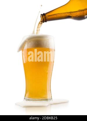 pouring blonde beer into glass with splashing foam, on white background Stock Photo