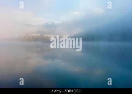 Fog rises off of One Mile Lake on a crisp fall morning in Pemberton, British Columbia. Stock Photo