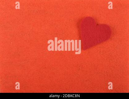 Heart of felt on red background Stock Photo